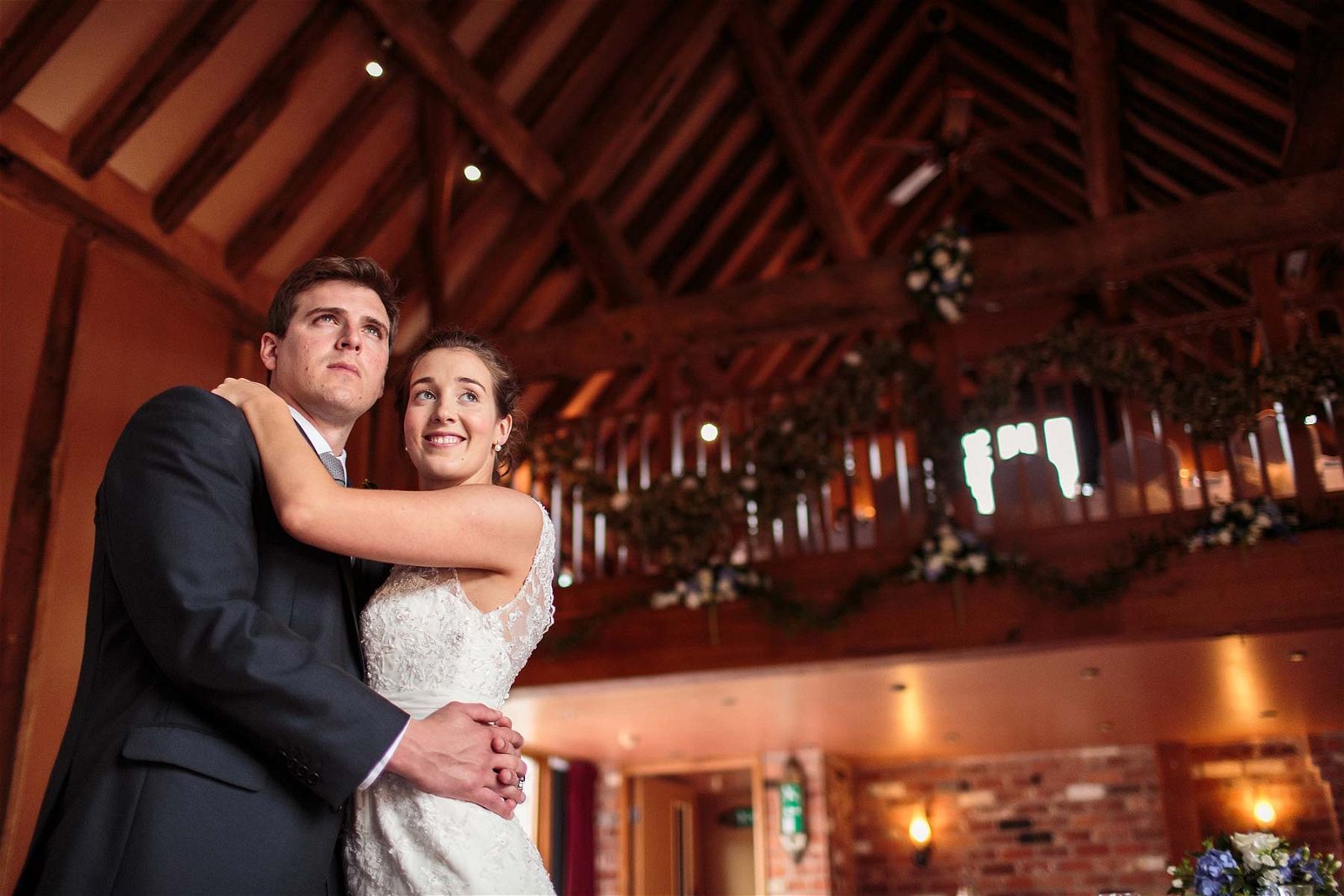 A wonderful intimate embrace between the Bride and Groom in the Tithe Barn at Hundred House Hotel in Norton by Shropshire Documentary Wedding Photographer Stuart James