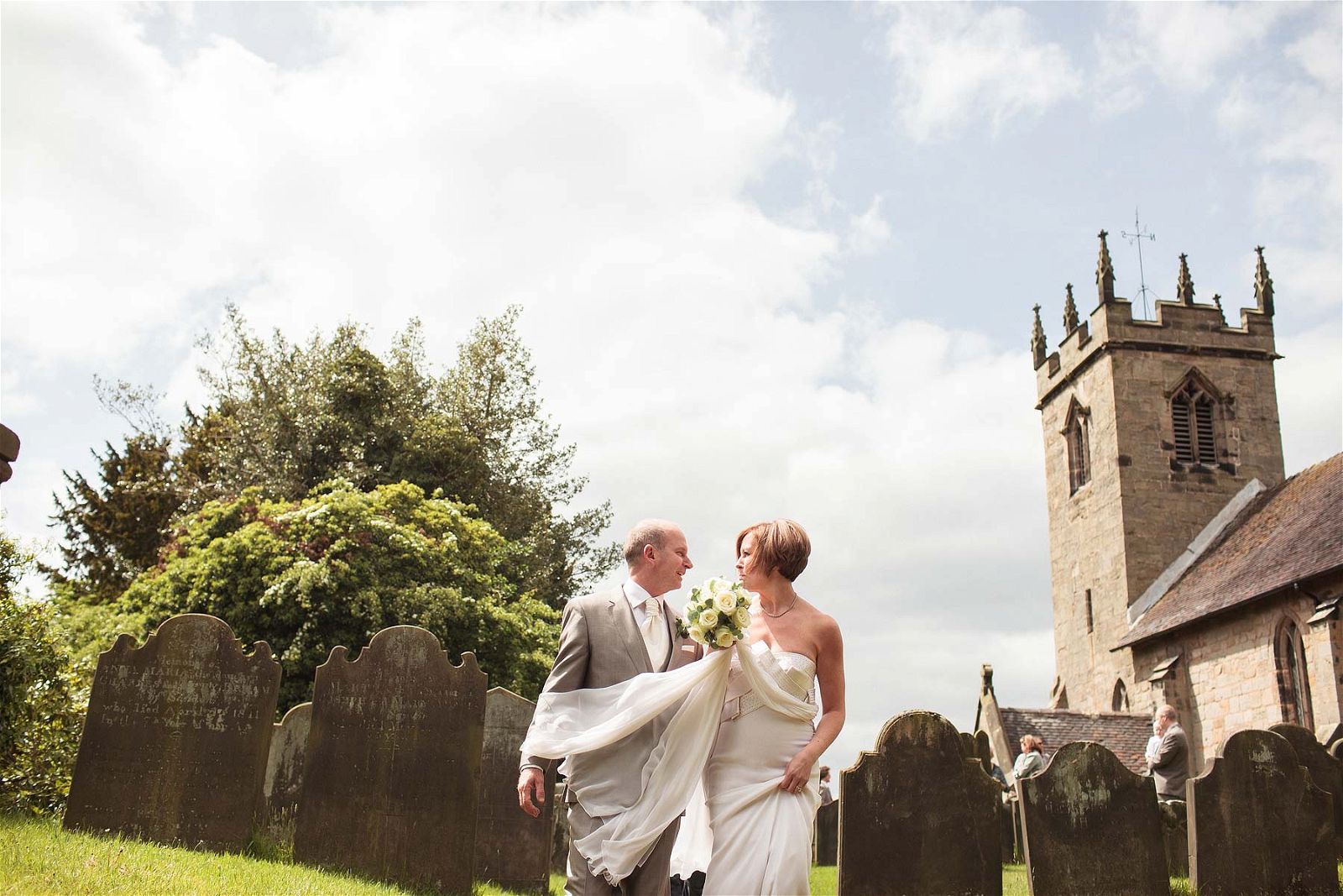 Happy married couple at All Saints Church in Sandon by Staffordshire Wedding Photographer Stuart James