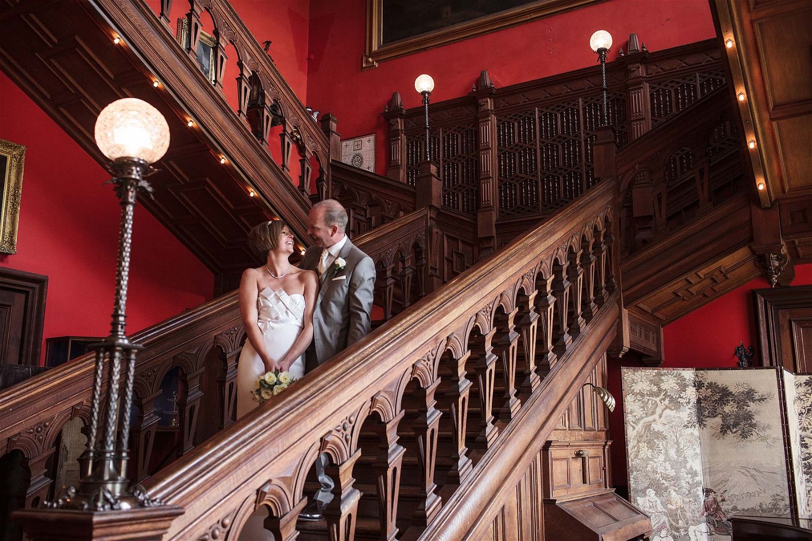 Elegant portrait on Bride and Groom Grand Staircase at Sandon Hall in Staffordshire by Recommended Wedding Photographer Stuart James