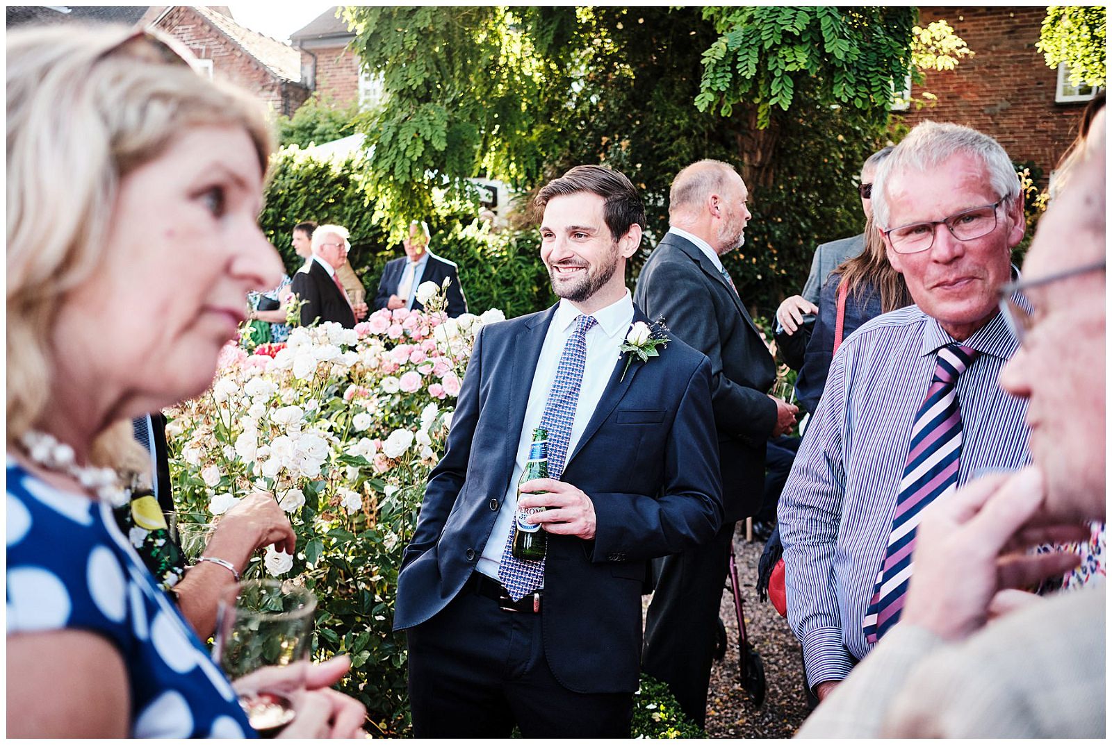 Candid photographs of the guests enjoying the wedding drinks reception in the summer sun at Goldstone Hall in Shropshire by Documentary Wedding Photographer Stuart James